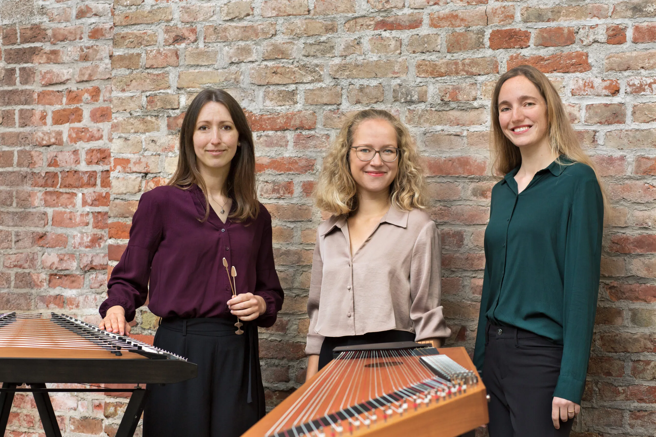 Trio zeitgelöst vor einer Backsteinwand